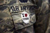 A U.S. airman assigned to the 180th Fighter Wing in Swanton, Ohio, wears a voting sticker on Election Day 2016. (U.S. Air National Guard photo by Staff Sgt. Shane Hughes)